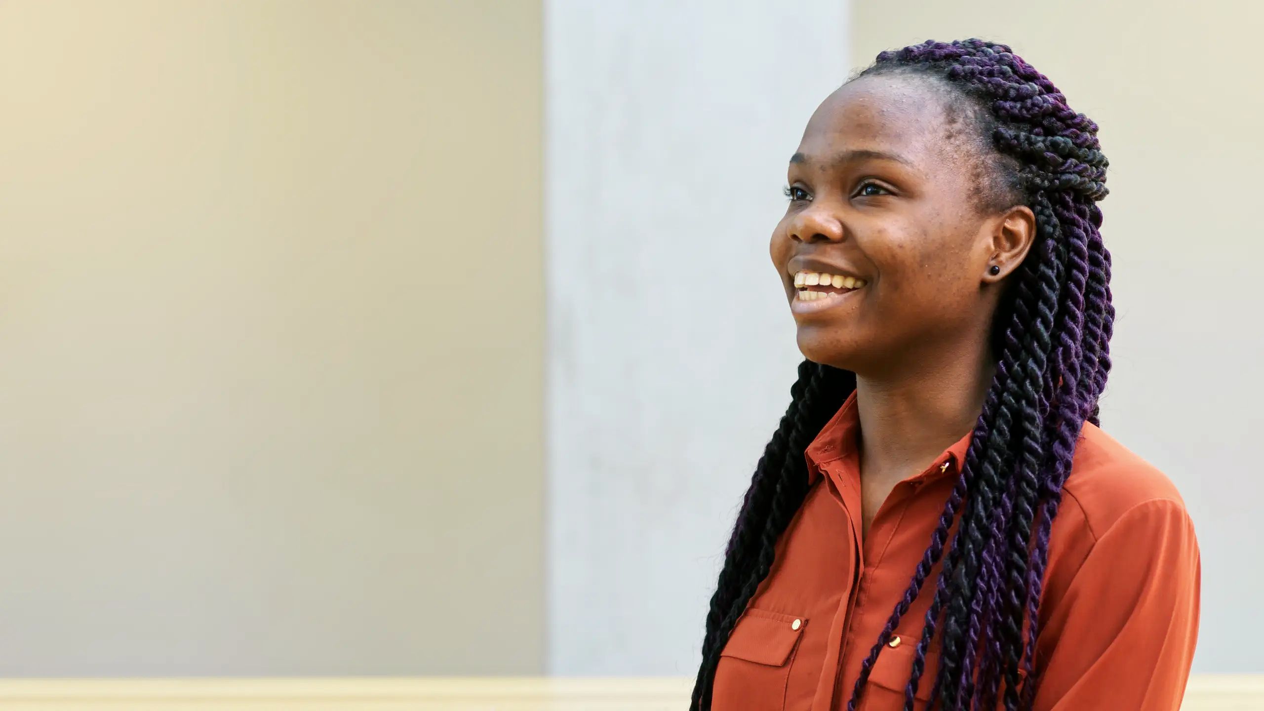 A student sits and smiles.