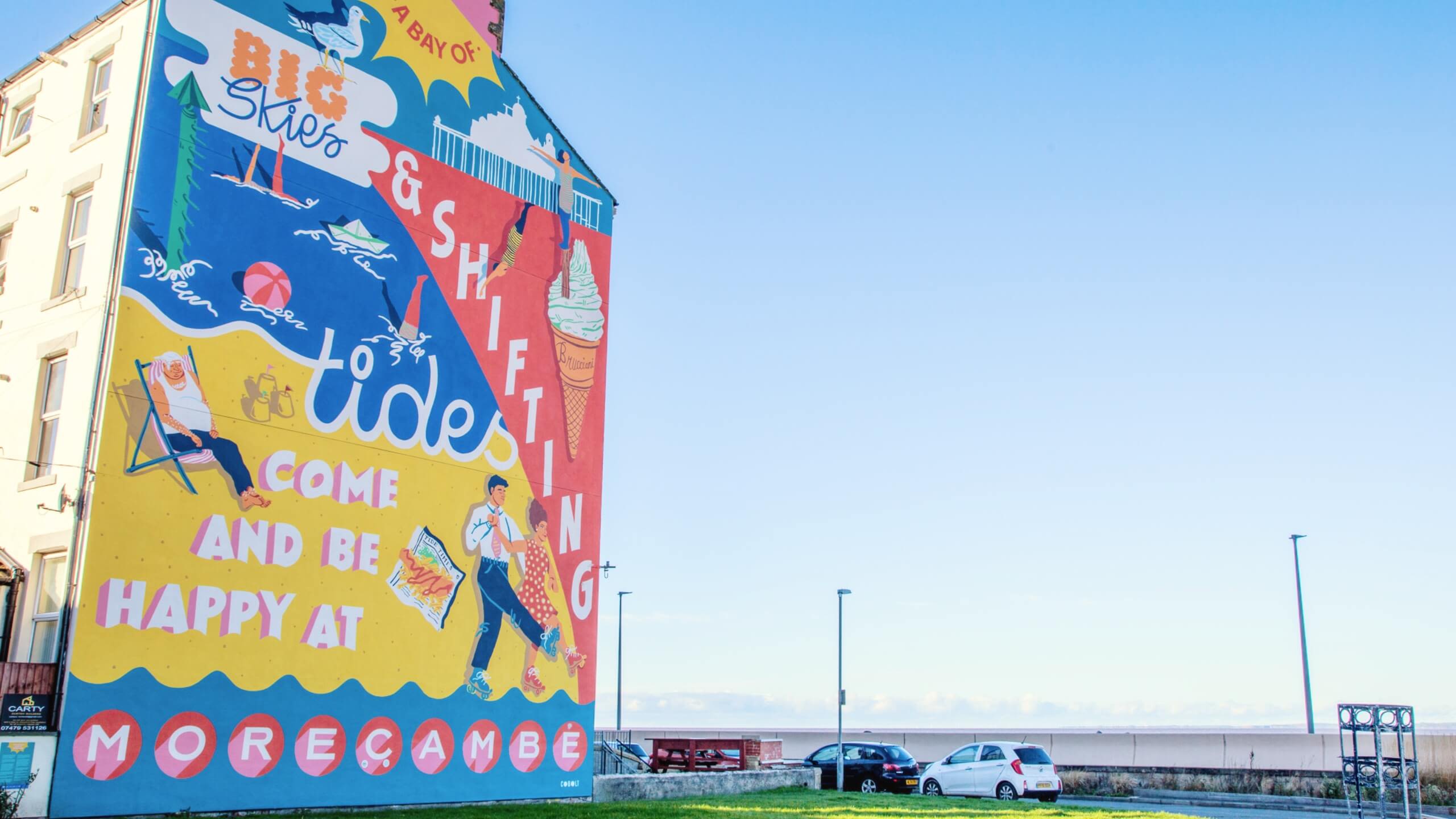A large colourful mural on the side of a house in Morecambe overlooking the sea.