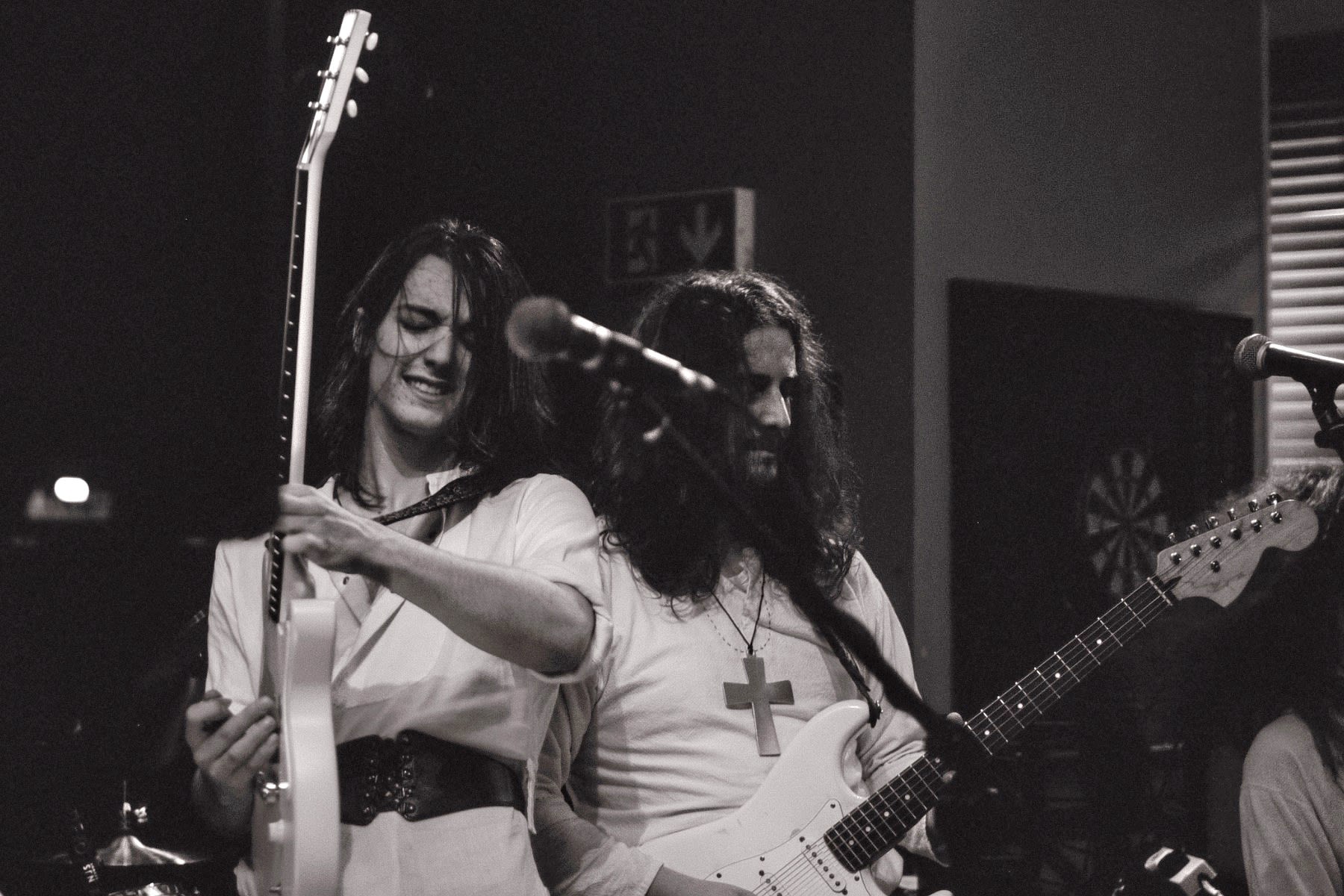 A black and white photo of a rock band performing in a local pub.