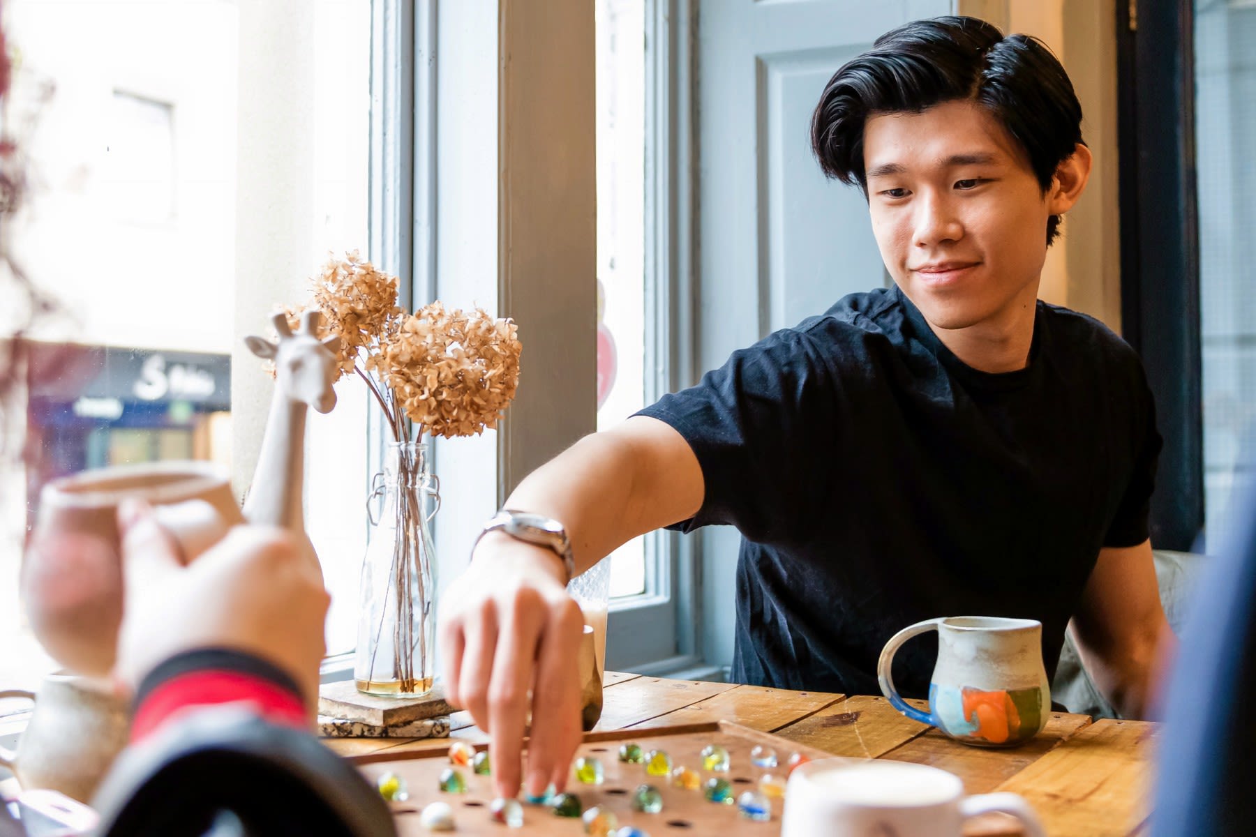 Students playing a board game in The Herbarium Cafe.