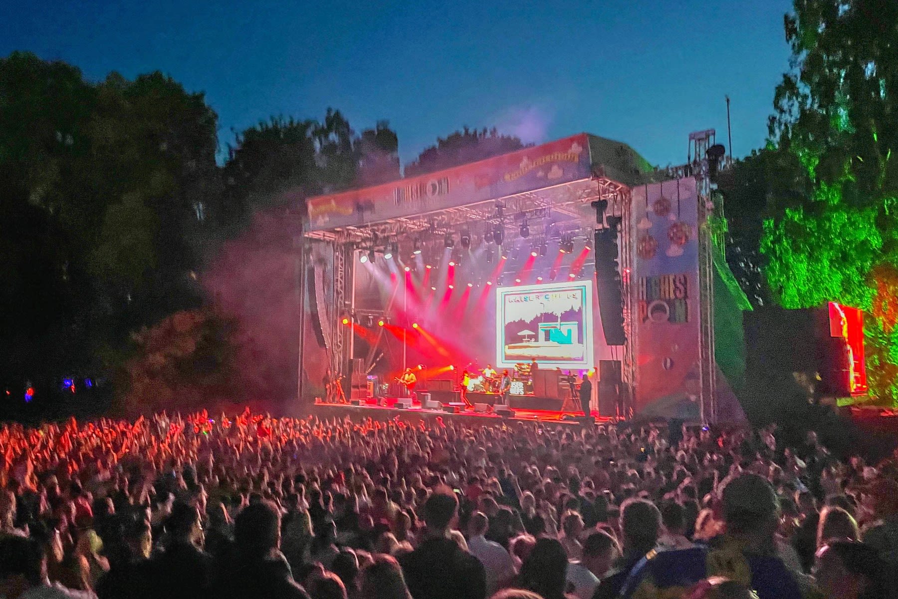 A band perform ona stage flooded with red lights at Highest Point festival.