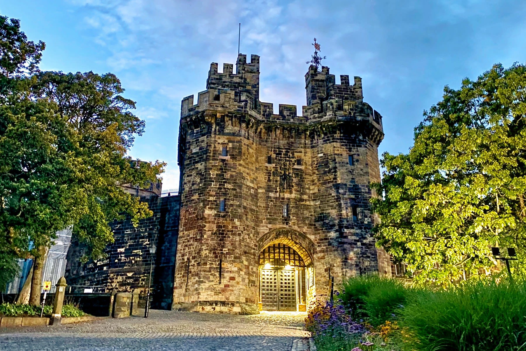 Lancaster Castle at sunset with the entrance gate lit up.
