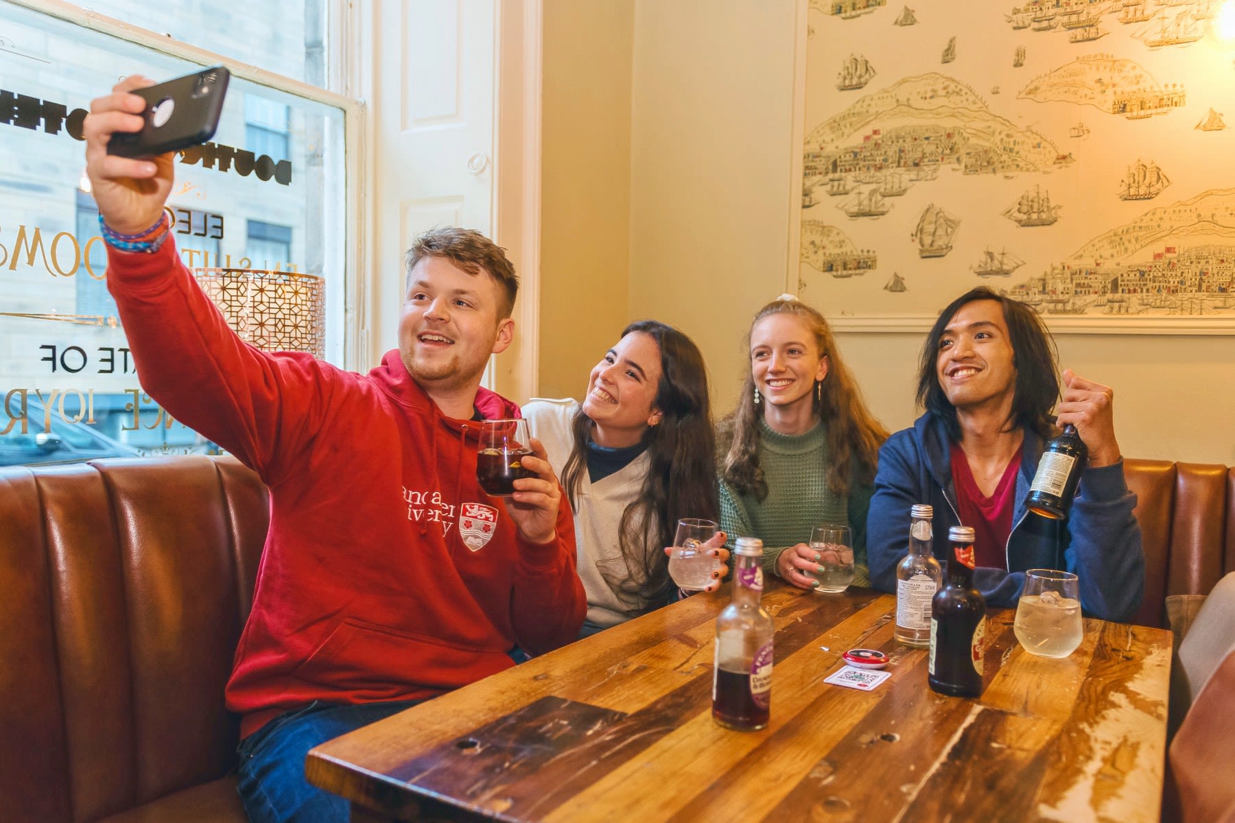 A group of students pose for a selfie in a pub.