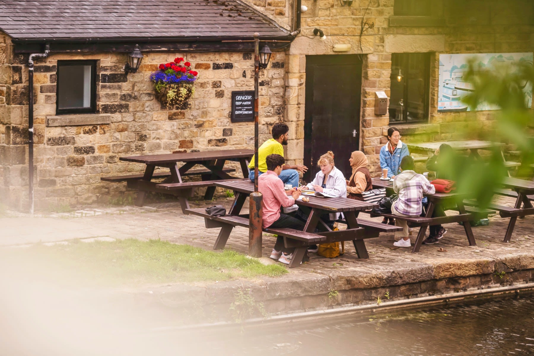 Students sit on two benches alongside the canal.