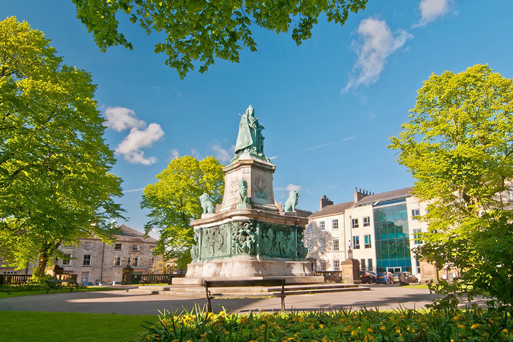A bronze statue of Queen Victoria on a large plinth in Dalton Square in Lancaster.
